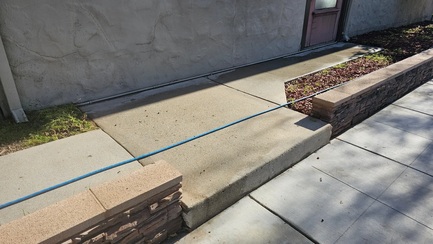 Same residential concrete walkway restored to clean concrete after Transparent Solutions pressure washing
