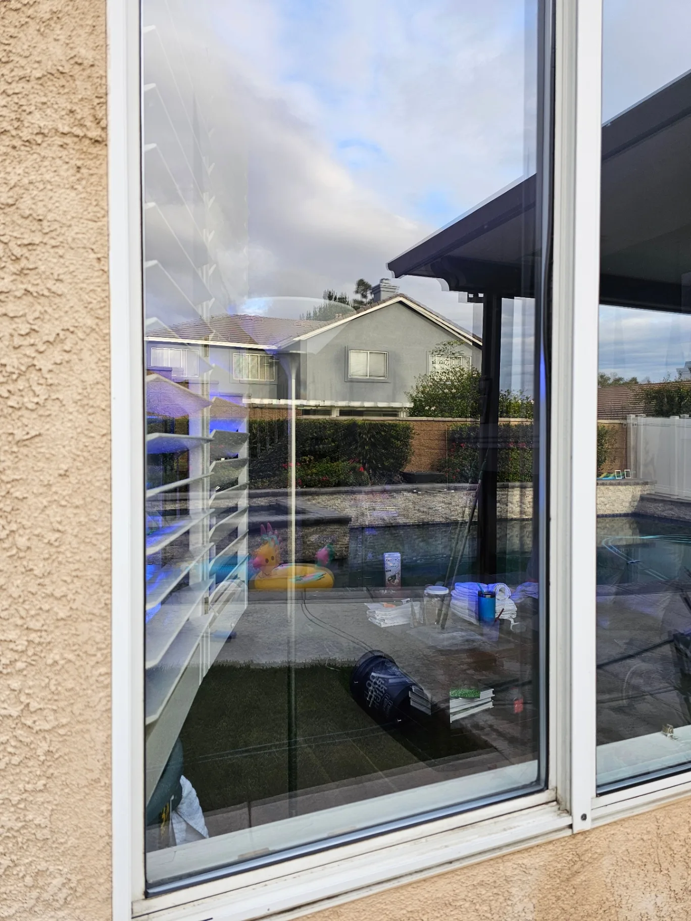 Same sliding glass door cleaned to a clear poolside view after Transparent Solutions service