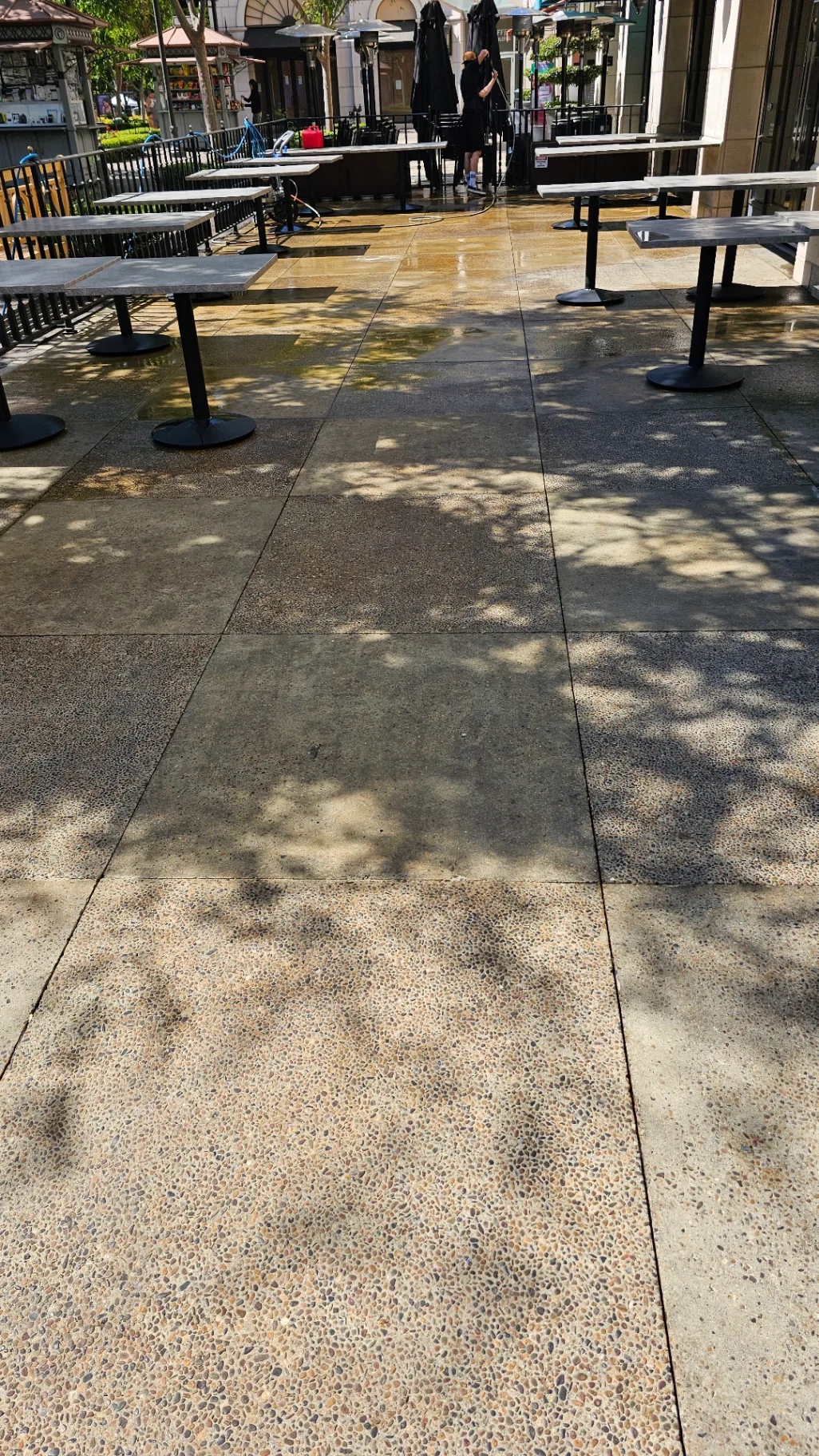 Crew pressure washing an outdoor restaurant patio at a commercial shopping center