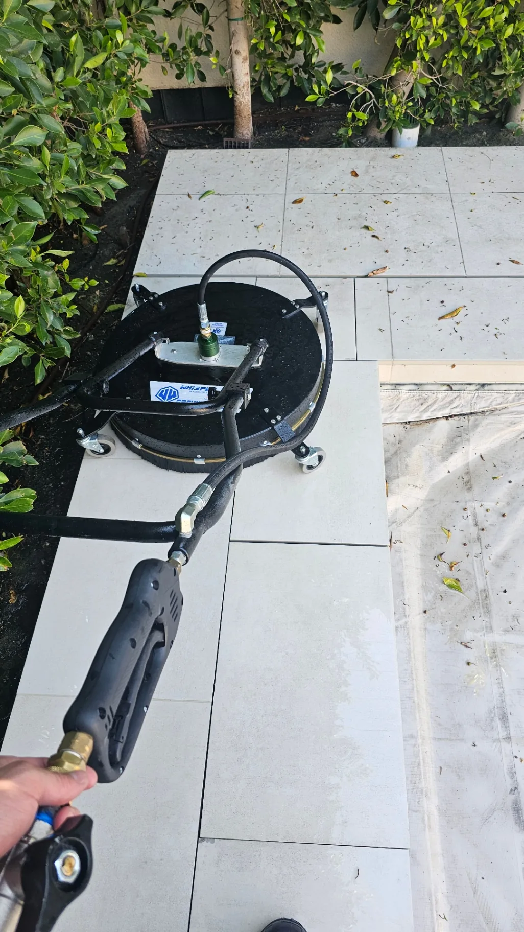 Surface cleaner positioned on a tile patio during a pressure washing service