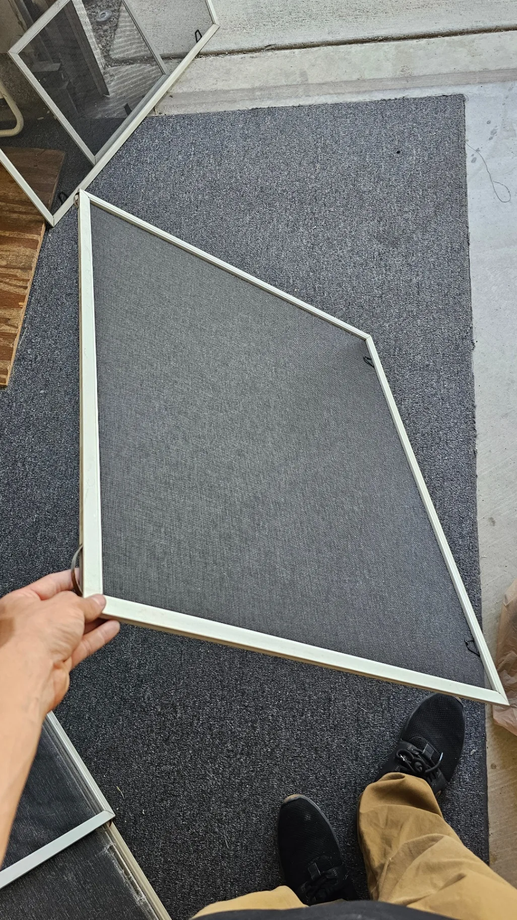 Same window screen frame freshly re-meshed with new charcoal screen mesh after Transparent Solutions screen replacement