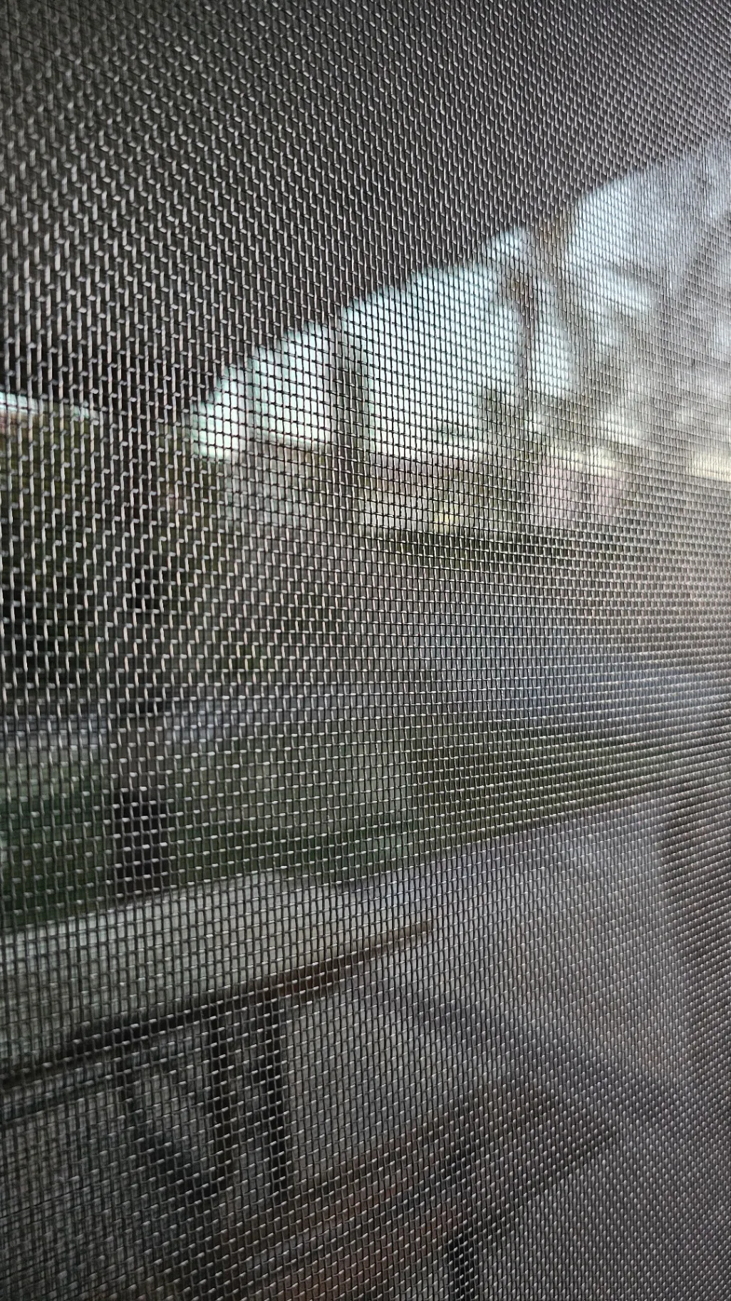 Close-up of new screen mesh installed in a residential window screen frame