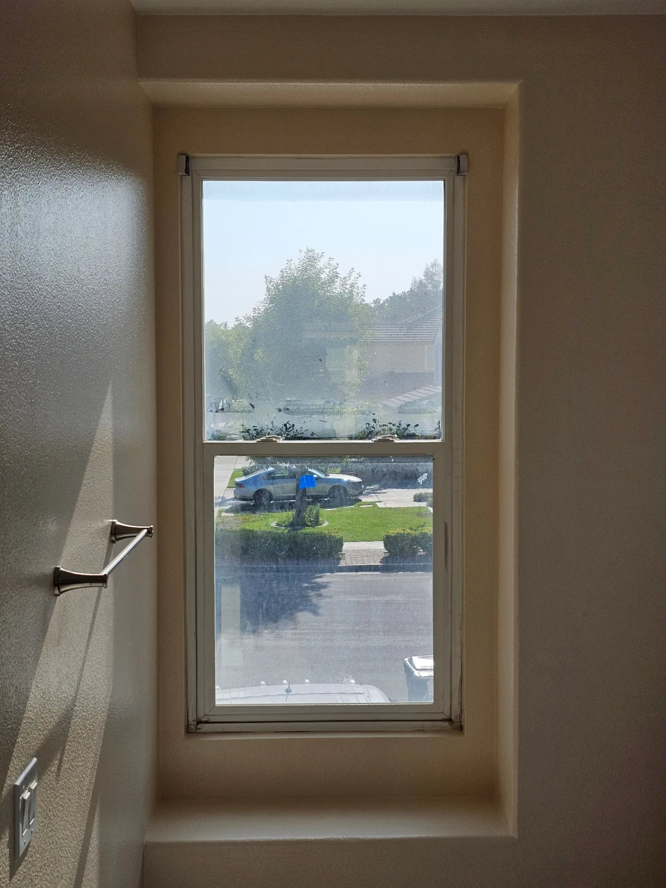 Hazy interior window with a dust-covered view before Transparent Solutions cleaning