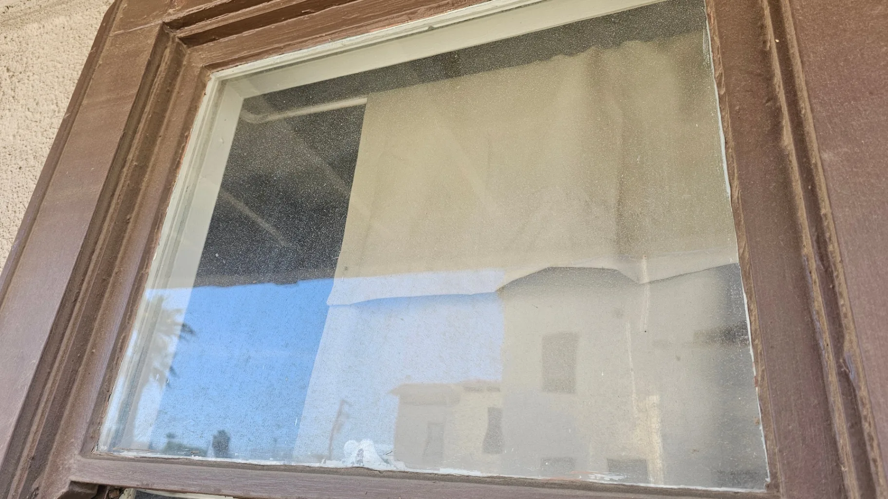 Dust and grime built up on an exterior window pane before Transparent Solutions cleaning