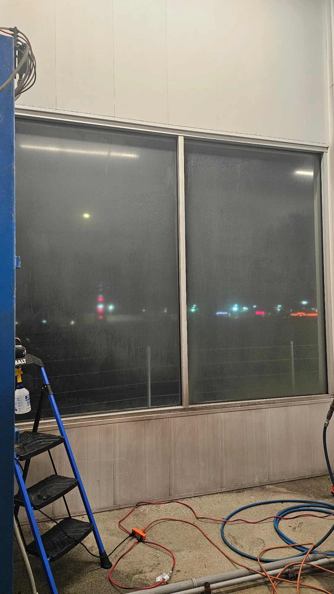 Commercial storefront glass coated in heavy mineral deposits before Transparent Solutions hard water removal